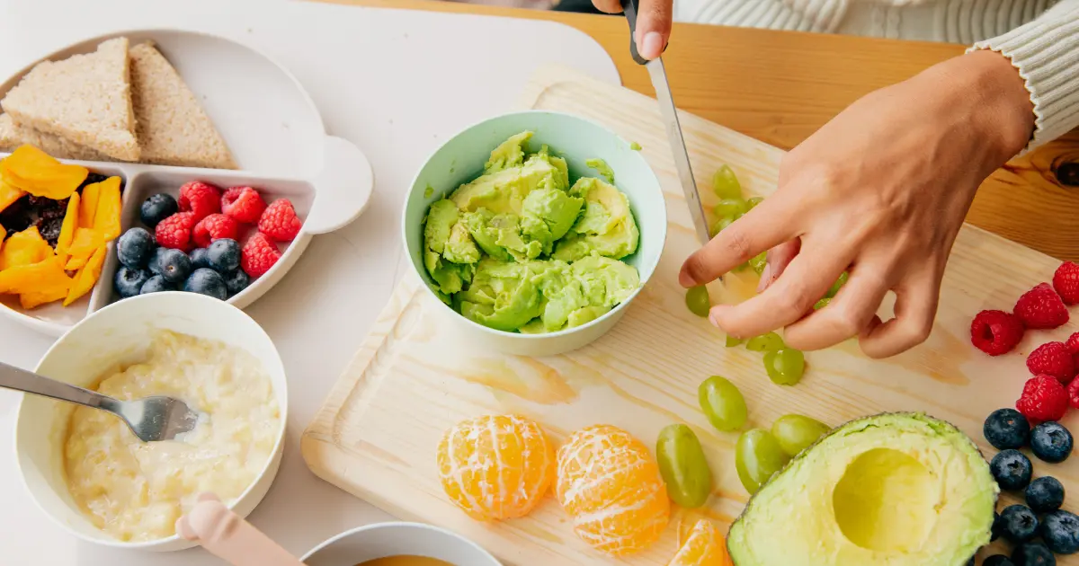 A woman preparing a nutritious PCOS-friendly breakfast in a bright kitchen, assembling ingredients like fresh berries, Greek yogurt, and whole grains on the counter.