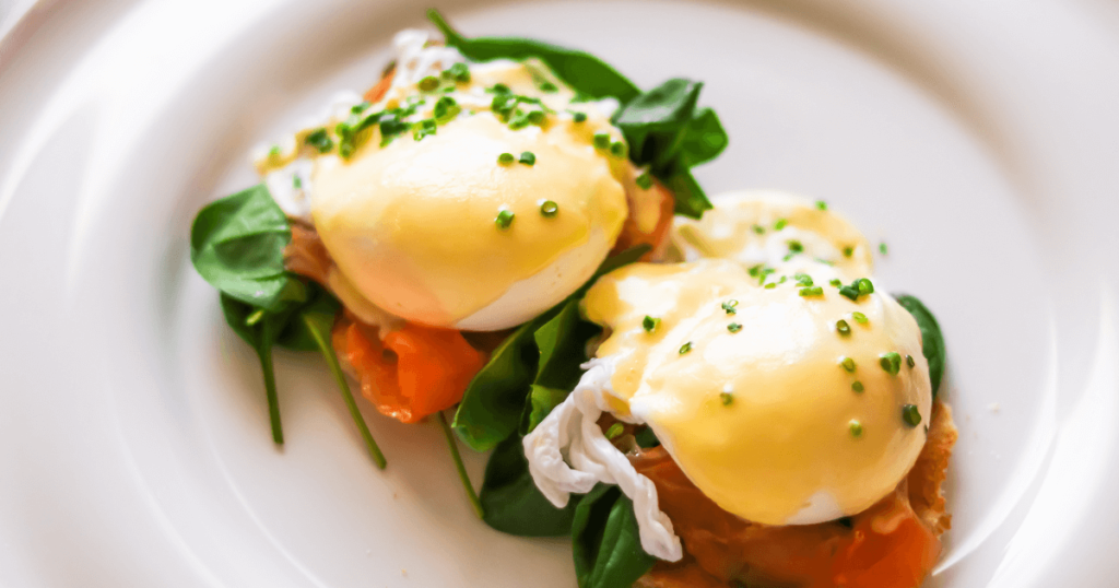 Plate featuring smoked salmon and poached eggs, garnished with fresh dill and black pepper, ideal for salmon breakfast recipes.