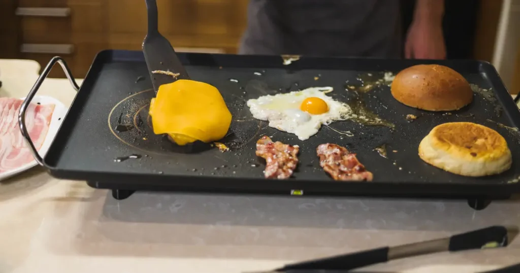 Sunny side up eggs cooking evenly on a hot Blackstone griddle, with the yolks intact and whites turning perfectly opaque.