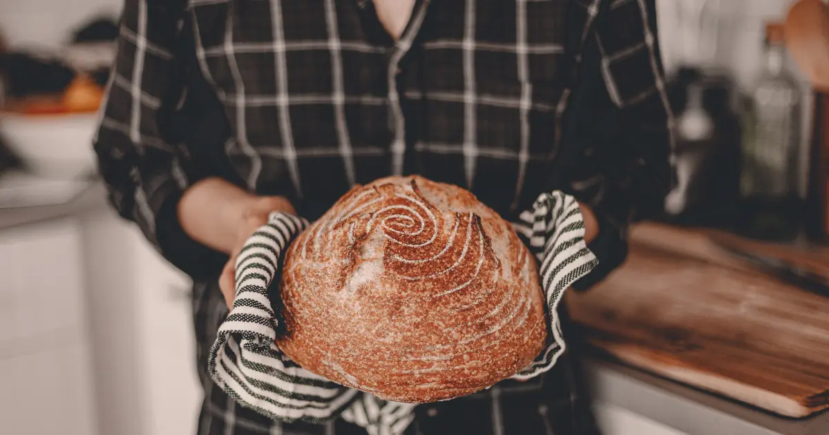 A woman enjoying breakfast with a slice of sourdough bread on her plate