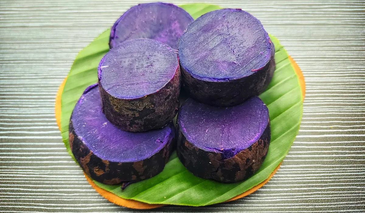 Close-up of sliced purple sweet potato on a white plate, showcasing vibrant colors and natural textures.