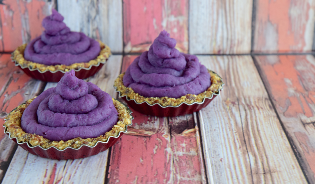 A freshly baked Purple Sweet Potato pie, displayed on a rustic wooden table.